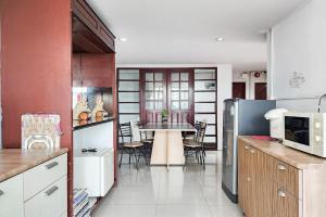 a kitchen with a table and a dining room at Freesia Bangphi Guest House in Samutprakarn