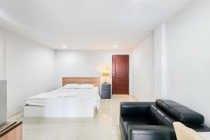 a white bedroom with a bed and a couch at Freesia Bangphi Guest House in Samutprakarn
