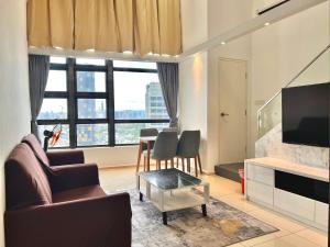 ein Wohnzimmer mit einem Sofa und einem Tisch in der Unterkunft Eko Cheras 时尚复式公寓loft,两室一厅 in Kuala Lumpur