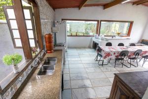 a kitchen and dining room with a table and chairs at Rec. Harmonia Wi-Fi Piscina Churrasqueira Lareira in Juquitiba
