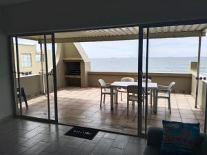 a dining room with a table and chairs and the ocean at 5 Telena in Umdloti +11 photos