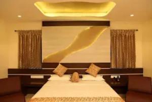 um quarto com uma cama com uma grande pintura na parede em Hotel SBS Grand , Coimbatore em Coimbatore