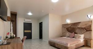 a bedroom with a large bed and a desk in it at Four Seasons In Carpathians in Migovo