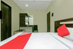 - une chambre avec un grand lit blanc et une couverture rouge dans l'établissement OYO Parimeet Hotel, à Turambhe