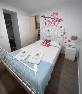 a bedroom with a white bed with two plates on it at Apartamento com pátio em frente praia in Paço de Arcos