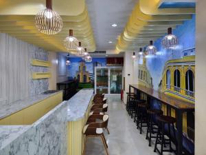 un restaurante con un bar con sillas y luces en Alaita Hostel Patong, en Patong Beach