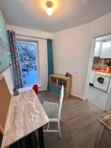 ein Wohnzimmer mit einem Tisch und einem Fenster in der Unterkunft Apartamento com pátio em frente praia in Paço de Arcos