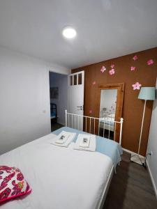 a bedroom with a bed with flowers on the wall at Apartamento com pátio em frente praia in Paço de Arcos