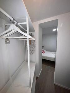ein weißes Zimmer mit einem Etagenbett und einer Treppe in der Unterkunft Apartamento com pátio em frente praia in Paço de Arcos