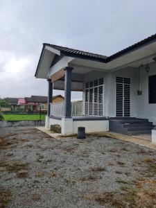 mały biały dom z ogródkiem w obiekcie Teratak Che Esah Guest House FREE WIFI NETFLIX w mieście Pasir Mas