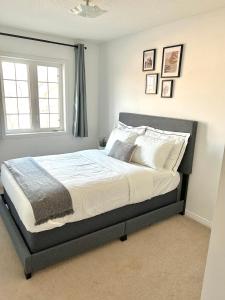 1 dormitorio con 1 cama grande con sábanas y almohadas blancas en Cozy home in Brampton (Mt pleasant Go station), en Brampton