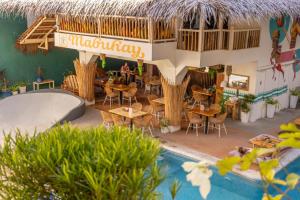 un ristorante con tavolo, sedie e piscina di Happiness Hostel Boracay a Boracay
