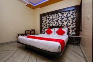ein Schlafzimmer mit einem großen Bett mit roten Kissen in der Unterkunft Hotel J P Inn Near Patel Nagar Metro Station in Neu-Delhi