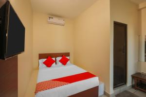 a bedroom with a bed with red pillows at OYO Jk Inn in Narasimharaja Puram