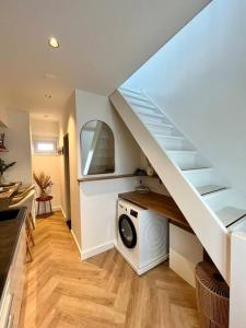 Un lave-linge est installé sous un escalier dans une maison. dans l'établissement Tiny House in center Aalsmeer I Close to Schiphol & Amsterdam, à Aalsmeer