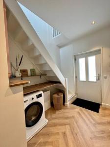 a washing machine in a laundry room with a staircase at Tiny House in center Aalsmeer I Close to Schiphol & Amsterdam in Aalsmeer