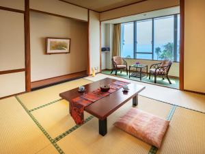 a living room with a table and a dining room at Ibusuki Phoenix Hotel in Ibusuki