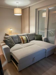 ein Wohnzimmer mit einer weißen Couch in einem Zimmer in der Unterkunft Helsinki Airport Apartment in Vantaa
