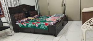 a bed with a green blanket and pillows on it at 4 KING SIZE BEDROOM DUPLEX VILLA in Hyderabad