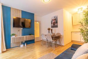 sala de estar con mesa y pared azul en 9 min to City Center via Metro 1BR 1LR with Balcony, en Viena