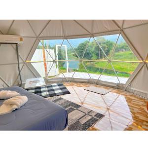 uma tenda com uma cama e uma grande janela em Dome Tent em Ban Pa Lau