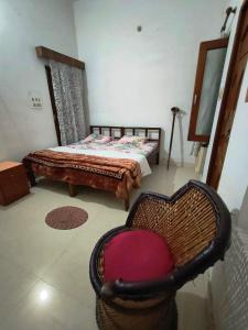 a bedroom with a bed and a chair in it at Royal Guest House in Bharatpur