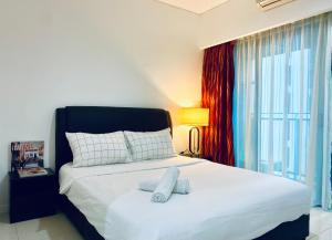 een slaapkamer met een groot wit bed en een raam bij Apartment near KLCC by GRIHOZ in Kuala Lumpur