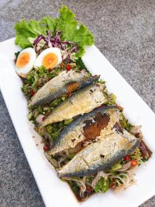 un plato de comida con pescado y huevos. en Dome Tent, en Ban Pa Lau
