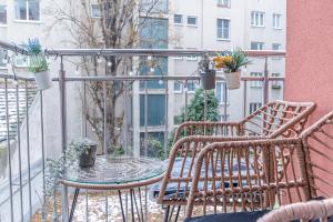 Un balcón con 2 sillas y una mesa con plantas. en 9 min to City Center via Metro 1BR 1LR with Balcony, en Viena