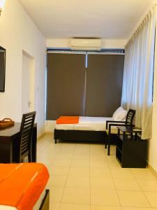 a room with a bed and two chairs and a window at Asian House in Colombo