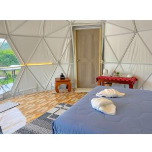 um quarto com uma cama azul numa tenda em Dome Tent em Ban Pa Lau