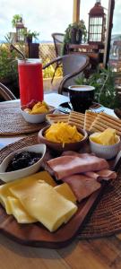 un plato de queso y otros alimentos en una mesa en PARAÍSO Sunset Bungallows, en Hanga Roa