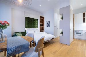 a bedroom with a bed and a dining room with a table at Ruzop Apartament self check-in in Poznań