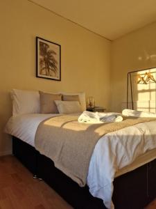 um quarto com uma cama grande e lençóis brancos em Central location em Londres