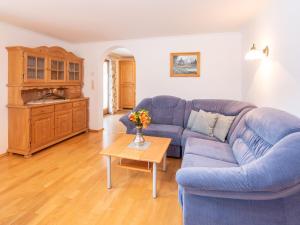 sala de estar con sofá azul y mesa en Cozy apartment in Wald im Pinzgau with balcony and barbecue area, en Wald im Pinzgau
