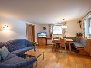 a living room with a blue couch and a table at Cozy apartment in Wald im Pinzgau with balcony and barbecue area in Wald im Pinzgau