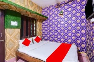 a bedroom with a bed and a blue wall at Goroomgo Sri Jagannath Nibas Puri in Puri