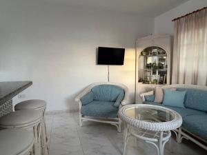 sala de estar con sofá, sillas y mesa en Ocean and Mountain View Penthouse by Dream Homes Tenerife, en Puerto de Santiago