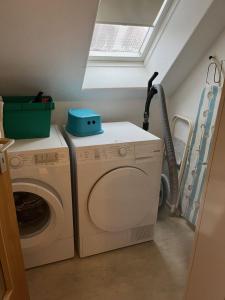 a laundry room with a washing machine and a window at Ferienwohnung Haus Schwalbennest OG in Ditzum