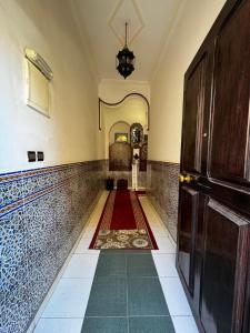 pasillo con alfombra roja y puerta en Dar Al Fassia, en Oujda