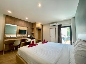 a bedroom with a large bed with red shoes on it at Room Actually in Karon Beach