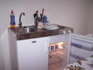 a kitchen with a sink and an open refrigerator at Objekt Nizna in Nižná