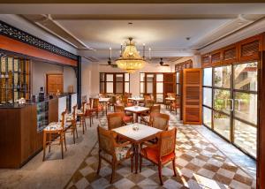 a restaurant with tables and chairs and a chandelier at Welcomhotel by ITC Hotels, Cathedral Road, Chennai in Chennai