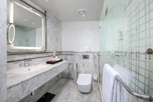 a bathroom with a sink and a toilet and a mirror at Welcomhotel by ITC Hotels, Cathedral Road, Chennai in Chennai