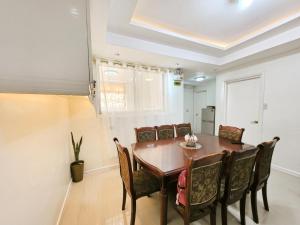 a dining room with a wooden table and chairs at Golden Queen Suites in Baguio