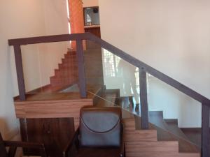 a stairway with a glass railing and a chair at Tulip In Green Meadows in Yercaud