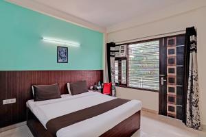 - une chambre avec un grand lit et une fenêtre dans l'établissement Super OYO Golden Imperial Near PVR Ansal Plaza Greater Noida, à Greater Noida