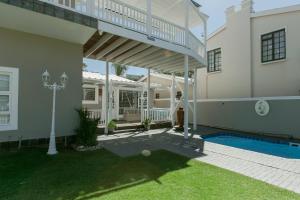 a house with a swimming pool and a balcony at Surf n Sea Beachfront Holiday Home in Jeffreys Bay