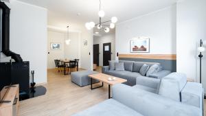a living room with a couch and a table at Wonder Home - Apartamenty Karkonosz blisko wyciągów narciarskich, szlaków i restauracji in Karpacz