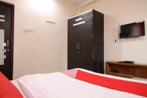a bedroom with a bed and a dresser with a tv at OYO Prithvi Inn in Dhantoli